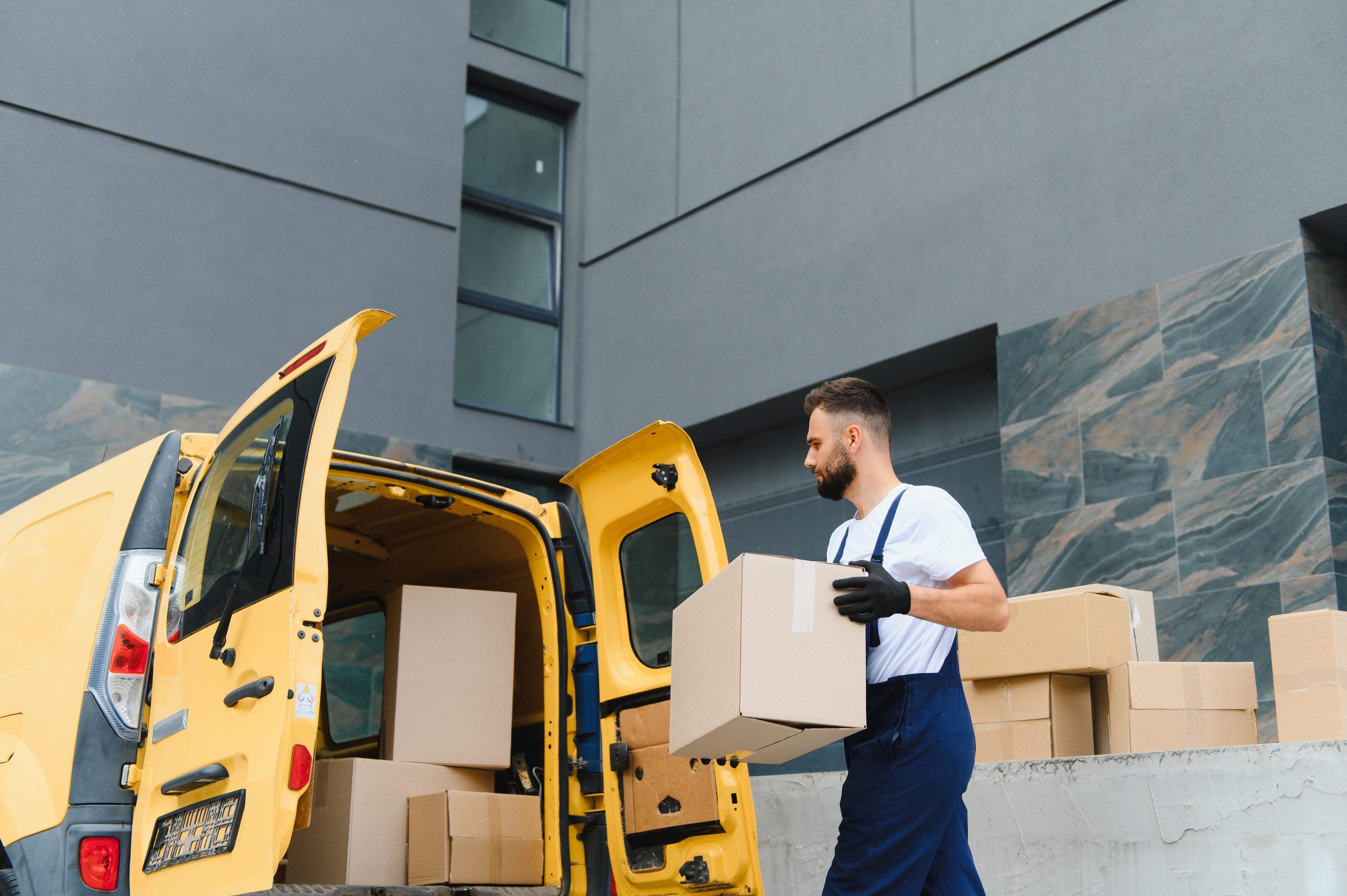 Courier Unloading Boxes From Delivery Van