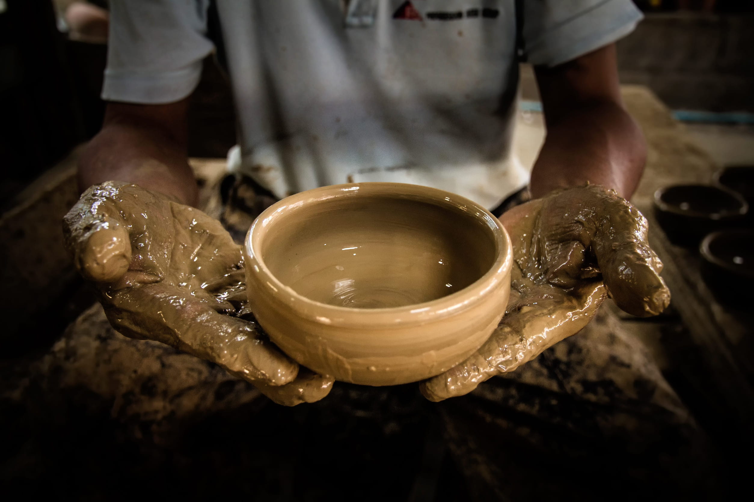 Handmade clay pottery being shaped and dried in a rural workshop