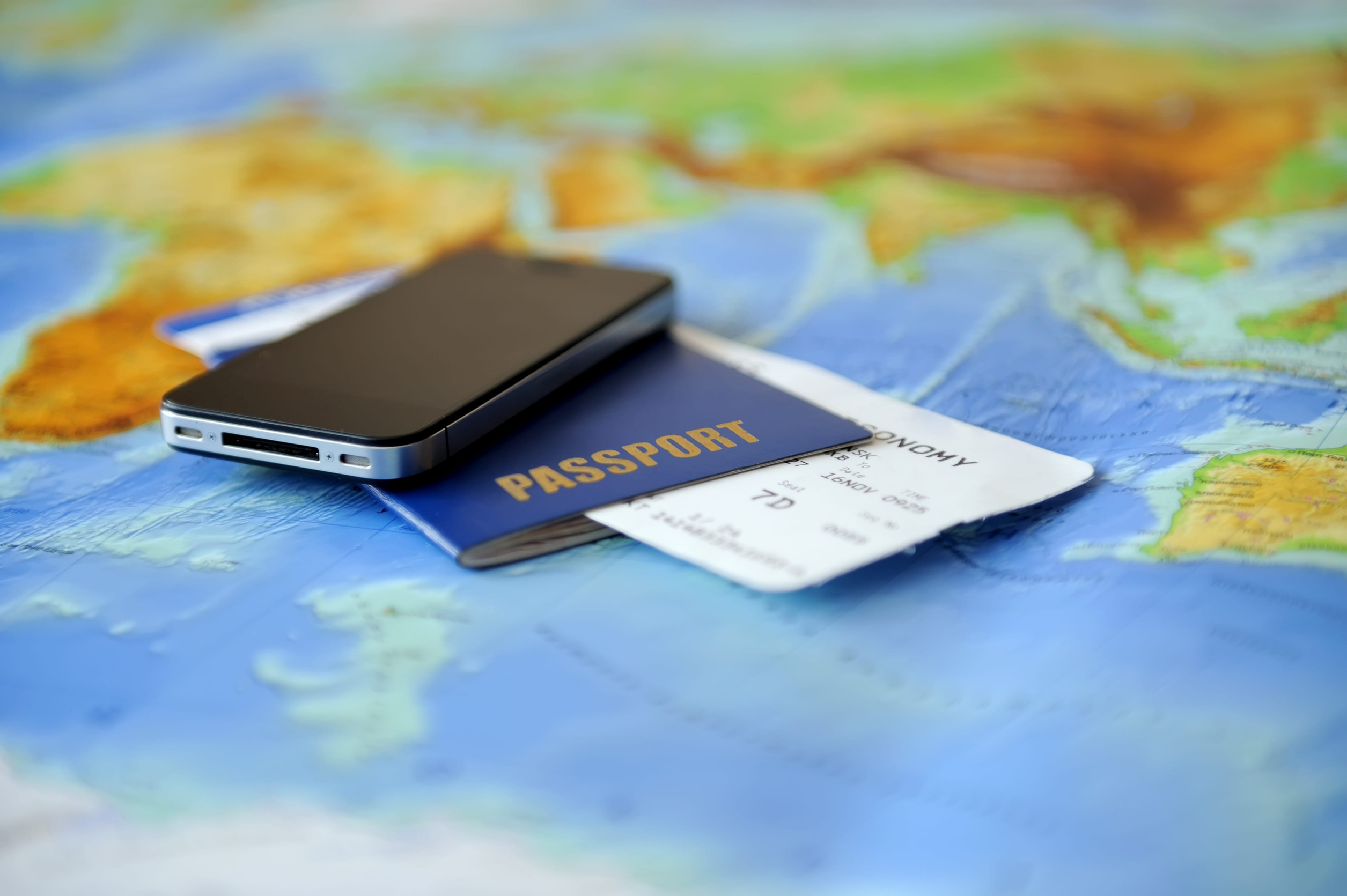 Passport, Ticket, and Phone on World Map